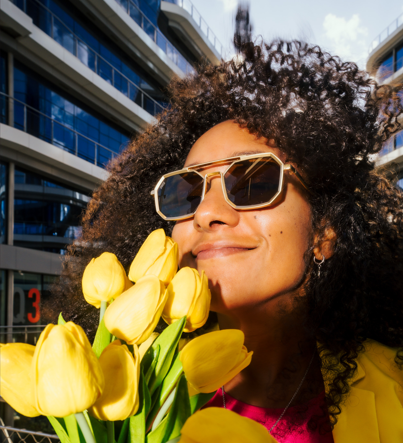 mujer con flores sonriente y gafas de sol